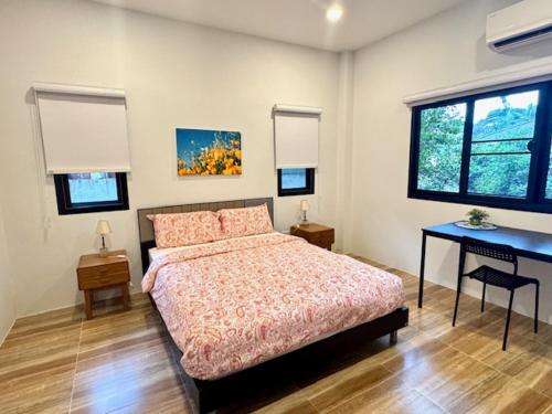 a bedroom with a bed and a desk in it at Mon Tresor Garden มง เทร ซอ in Amphoe Sawang Daen Din