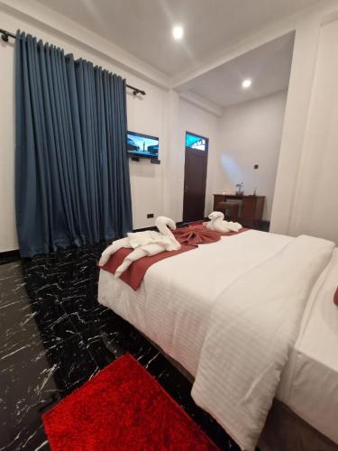 a bedroom with a large white bed with towels on it at ThiThi's Palace Mirissa in Mirissa