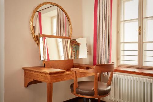 a dressing table with a mirror and a chair at Hotel Goldener Hirsch, A Luxury Collection Hotel, Salzburg in Salzburg