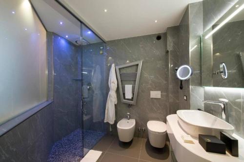 a bathroom with a sink and a shower and a toilet at Gatto Bianco Mia Aparthotel in Milan
