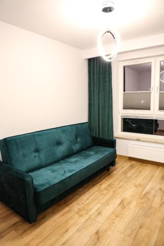 a green couch in a living room with a window at Apartament Królowej Jadwigi z garażem in Radom