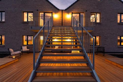 eine Treppe, die zu einem Gebäude mit Beleuchtung führt in der Unterkunft Apartments Rooftop Garden 5 -7 im Ostseeresort Olpenitz in Olpenitz