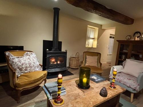 un salon avec un poêle à bois dans une pièce dans l'établissement Charming Normandy Cottage, à Saint-Julien-sur-Calonne