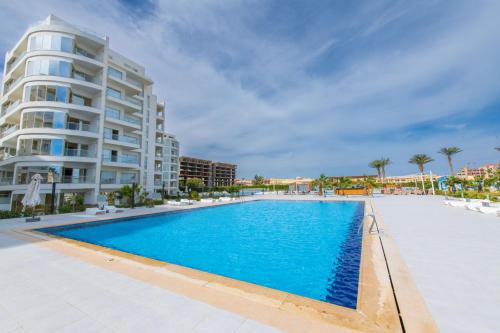 une grande piscine devant un immeuble dans l'établissement scandic resort 523, à Hurghada