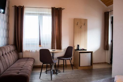 a living room with a couch and a table and chairs at URychertow in Kiełpino
