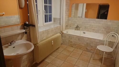 a bathroom with a sink and a tub and a toilet at La Madeleine in Nassogne