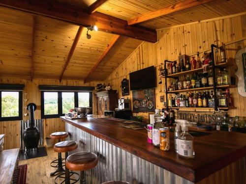 a bar in a cabin with wooden walls and wooden ceilings at Nature's Loft in Fouriesburg