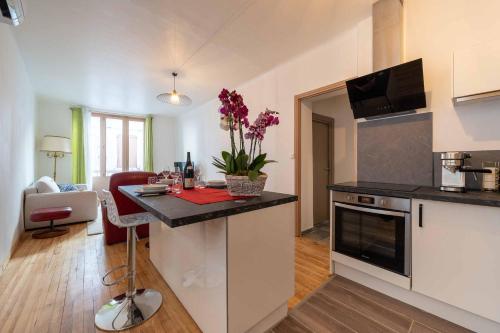 d'une cuisine et d'un salon avec un comptoir et une table. dans l'établissement Maison des orchidées, à Montélimar