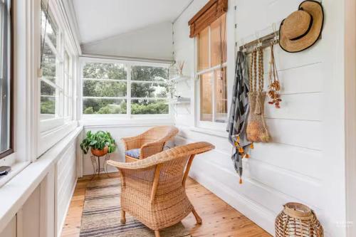 a hallway with two wicker chairs and a window at Highland Cottage- Modern Country Life at Leura in Leura