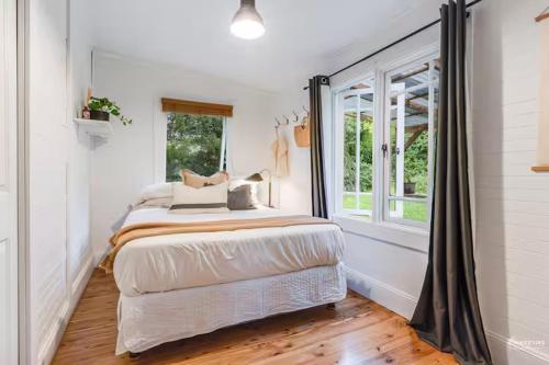 a bedroom with a bed and a window at Highland Cottage- Modern Country Life at Leura in Leura