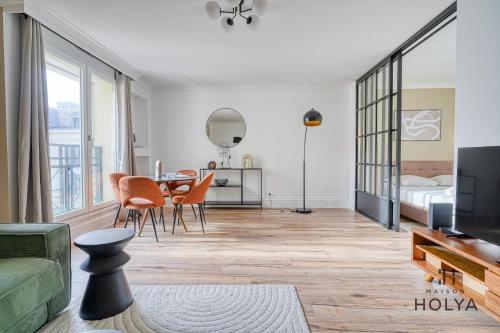 un salon avec un canapé et une table avec des chaises dans l'établissement Le Prisme - Au cœur de Versailles - 344B, à Versailles