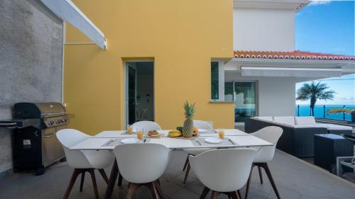 a dining room with a table and chairs and a grill at Estrela do Mar - by LovelyStay - Lovely, Sun Filled Villa in Calheta