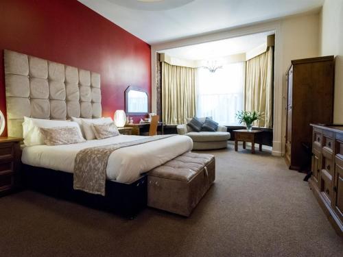 ピーターバラにあるThe Pearl Hotelの赤い壁のベッドルーム1室(大型ベッド1台付)