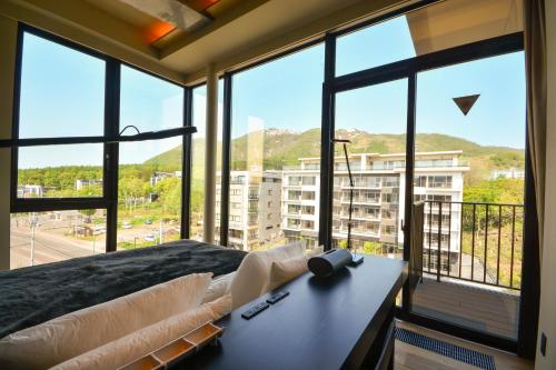 a room with a bed and large windows with a view at MUSE Niseko in Kutchan