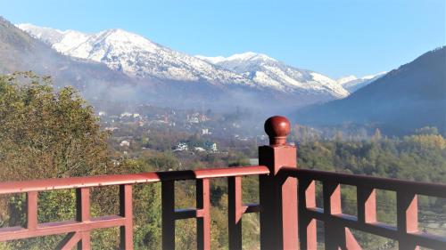 a balcony with a view of a snowy mountain at Regenta Inn by Riverside Manali in Manāli