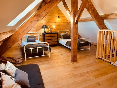 Cette chambre mansardée comprend 2 lits et des plafonds en bois. dans l'établissement Maison authentique au cœur des montagnes, 8pers, à Thiézac