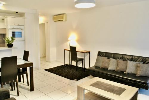 un salon avec un canapé noir et une table dans l'établissement Centre Riviera 2P LHO5516, à Cannes