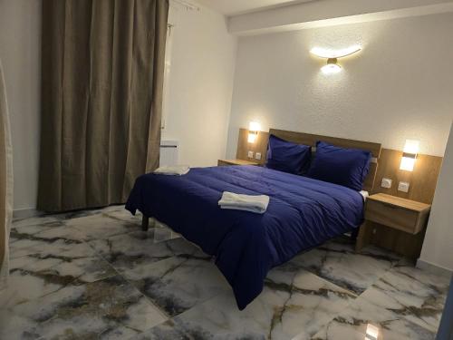 une chambre avec un lit avec une couette bleue dans l'établissement Les Hirondelles, à Andolsheim