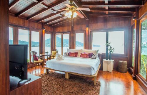 Un dormitorio con una cama y un televisor de pantalla plana. en Amara - Luxury Infinity Pool Villa with Sea view, en Surin Beach