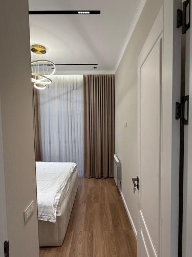 a bedroom with a bed and a room with a window at Apartment A in Dushanbe