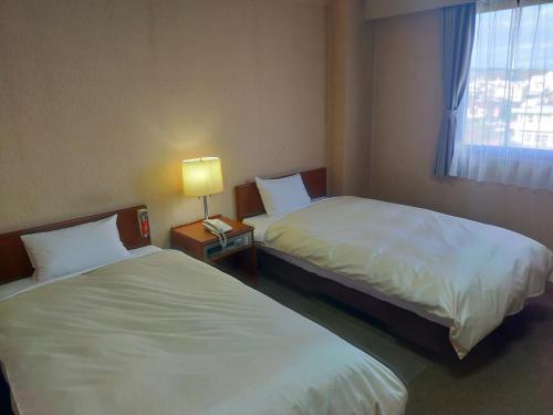 a hotel room with two beds and a window at Hotel Kurashiki Mizushima Hills in Chidorichō