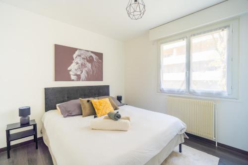 une chambre avec un lit avec un ours en peluche dessus dans l'établissement Escapade Confort au Cœur de la Ville Cosy&Moderne, à Saint-Julien-en-Genevois