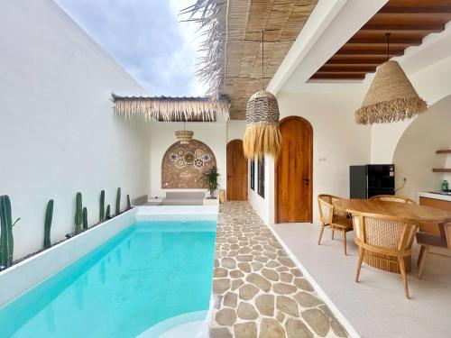 a pool in a house with a dining area and a table at Tujuan Jogja Villas Arjuna With Private Pool in Jetis