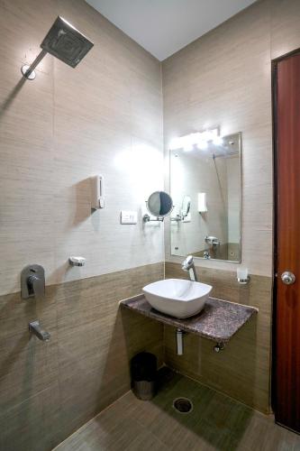 a bathroom with a sink and a mirror at The Golden Apple in Lucknow