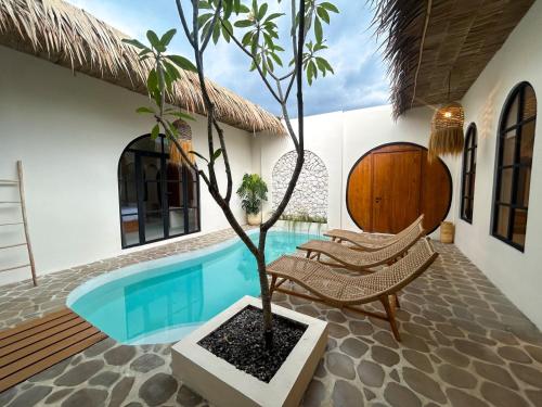 a house with a pool and a tree in the yard at Tujuan Jogja Villas Arjuna With Private Pool in Jetis