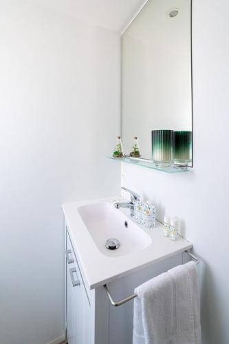 a white bathroom with a sink and a mirror at Club del Sole Adriatico Cervia Easy Camping Village in Cervia