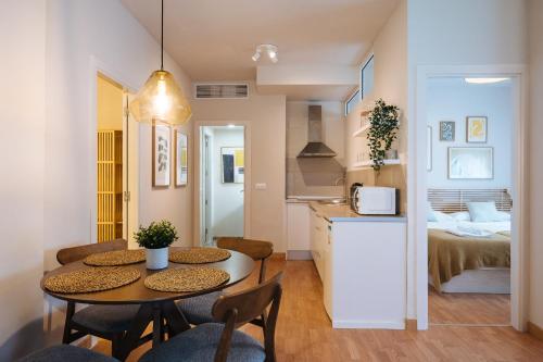 a kitchen and a living room with a table and chairs at Charming Apartment in the Heart of Triana, Seville in Seville