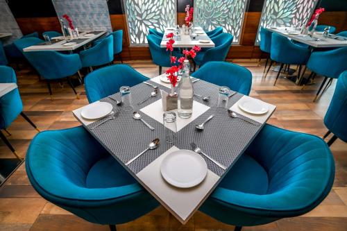 a dining room with a table and blue chairs at The Golden Apple in Lucknow
