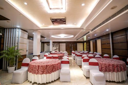 a banquet hall with red and white tables and chairs at The Golden Apple in Lucknow