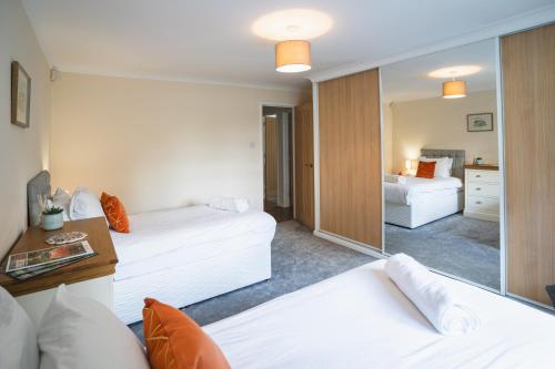 a living room with two white beds and a mirror at Little Hill Farm Villa in Ringwood