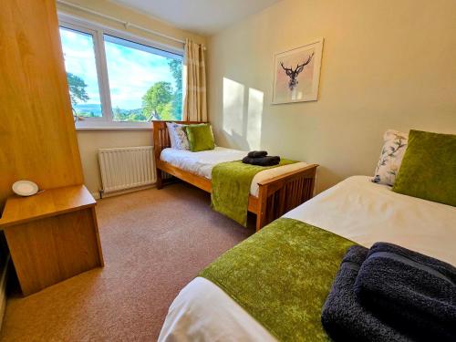 a small room with two beds and a window at Beautiful House in Perfect Bowness Location in Bowness-on-Windermere