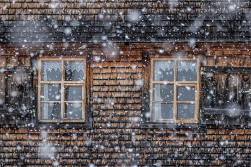 two windows on a brick building in the snow at Ferienhof Landerleben in Egg