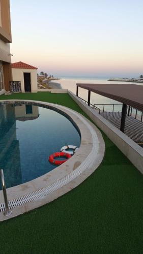a swimming pool with a red boat next to a building at Mora Hotel in Al Khobar