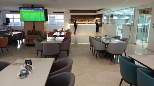 a dining room with tables and chairs in a restaurant at Mora Hotel in Al Khobar