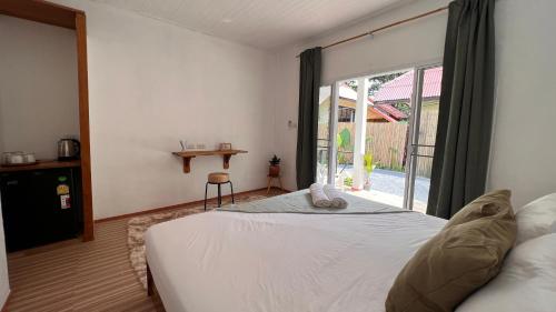 a bedroom with a bed and a large window at De Hope Kohlanta in Ko Lanta Yai