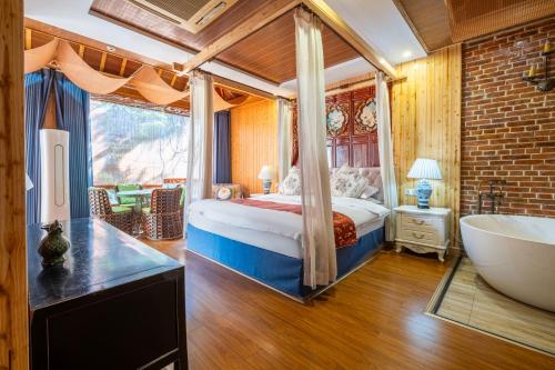 a bedroom with a bed and a tub in a room at Nanxun Luohua Old House Inn in Huzhou