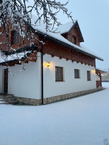 a house covered in snow with lights on it at Holiday home Marta in nature with jacuzzi in Gospić