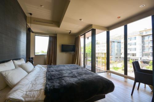 a bedroom with a large bed and large windows at MUSE Niseko in Niseko