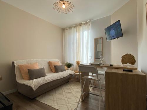 a living room with a couch and a table and a desk at Cocon Citron in Bergerac