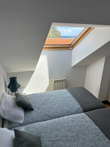 a bedroom with a large bed and a large window at Alojamiento Epìco in Candás