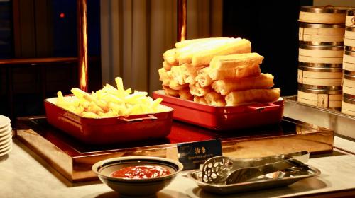 a buffet with two trays of cheese and french fries at Shanghai Hongqiao Yankuang Tulip Hotel in Shanghai