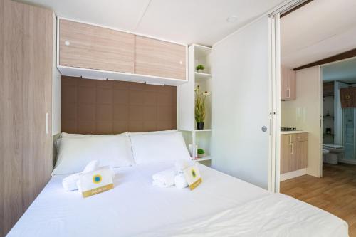a bedroom with a large white bed with two boxes on it at Club del Sole Adriatico Cervia Easy Camping Village in Cervia