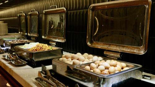 a kitchen with several trays of food on a counter at Shanghai Hongqiao Yankuang Tulip Hotel in Shanghai