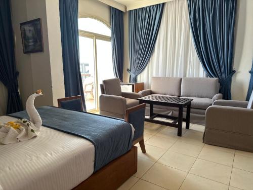 a hotel room with a bed and a living room at Elaria Hotel Hurgada in Hurghada