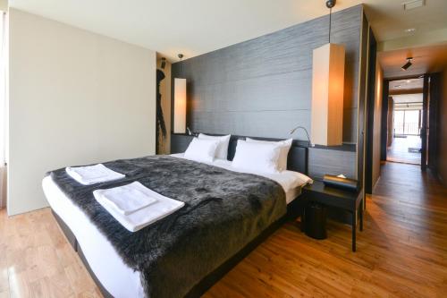 a bedroom with a large bed with a black headboard at MUSE Niseko in Kutchan