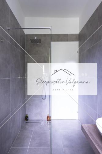 a bathroom with a shower with a glass door at SleepWell in Valganna in Valganna
